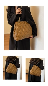 Detail view of large brown quilted tote bag with golden chain strap and refined texture