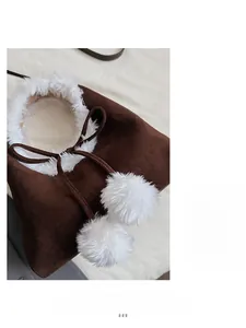 Détail du sac seau en daim marron avec bordure en fausse fourrure blanche et pompons