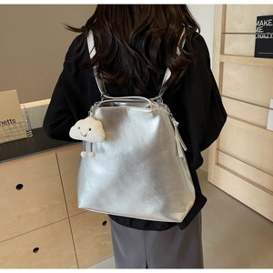 Silver metallic tote backpack detail with white cloud charm and leather texture finish
