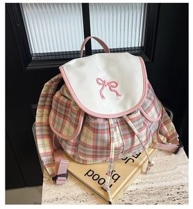 Detailed view of pink plaid fabric backpack with bow embroidery and drawstring closure