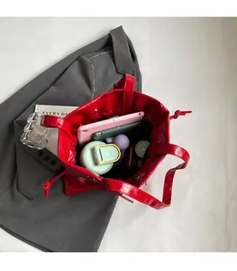 Interior view of red glossy tote bag showing large capacity for tablet and daily items