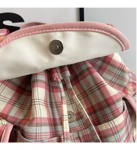 Detail of pink plaid fabric bag showing the magnetic buckle and drawstring closure