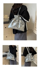 Detail of silver metallic bucket bag with drawstring closure and small bow accents