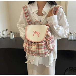 Detailed view of pink plaid fabric backpack with embroidery bow and side pockets