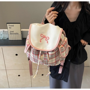 Détail du sac à dos à carreaux roses avec broderie nœud et fermeture à cordon coulissant