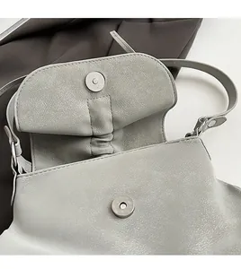 Detailansicht des Magnetverschlusses an der Tasche aus genarbtem Leder mit Lychee-Muster