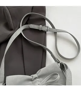 Detail eines verstellbaren Schultergurts und Silberschnalle an einer grauen Handtasche