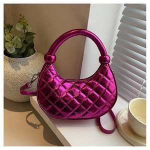 Detail of metallic purple quilted dumpling bag with glossy finish and elegant texture
