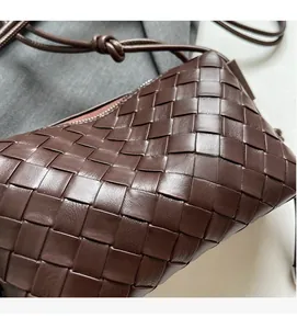 Close-up of dark brown woven leather texture on a stylish luxury crossbody pillow bag