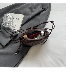 Detail view of woven leather crossbody bag interior showing spacious storage for daily items