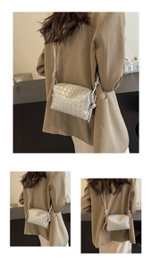 Detail of silver woven crossbody bag with wide Intrecciato pattern and knotted strap