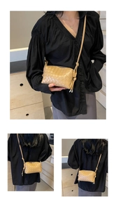 Detailed view of woven leather texture and knotted strap on beige square crossbody bag