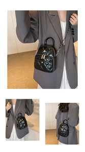 Détail du mini sac noir matelassé avec des rivets fleur et une bandoulière en chaîne