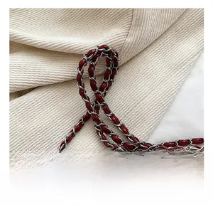 Vue macro détaillée de la bandoulière en cuir rouge et métal argenté d'un sac matelassé
