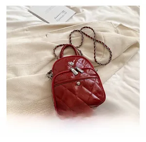 Vue détaillée du mini sac en cuir matelassé rouge foncé avec ornements de fleurs argentées