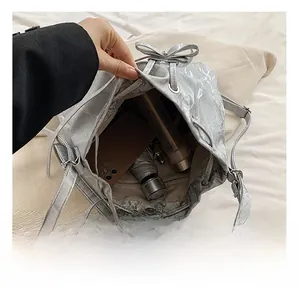 Detail view of large silver bucket bag interior holding umbrella and smartphone