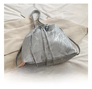 Close-up of silver bucket bag showing drawstring closure and metallic crinkled texture