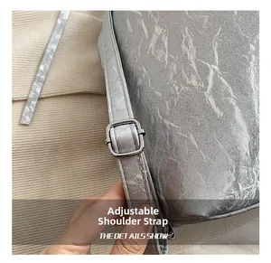 Detail showing the adjustable silver strap buckle and pleated metallic texture of the bag