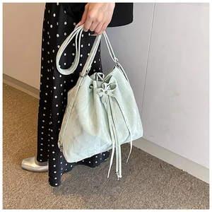 Detailed view of the mint green drawstring bucket bag with elegant bow tie decoration