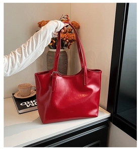 Large minimalist red faux leather tote bag for women shown in a modern lifestyle scene