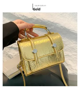 Detailed view of a gold metallic crackle texture messenger bag with elegant top handle