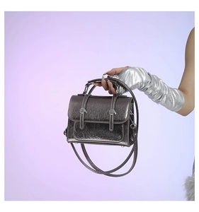 Detail showing metallic gunmetal crackle texture and metal handle of the messenger bag