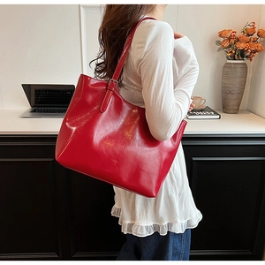 Professional detail view of a red shiny large capacity underarm tote bag for women.