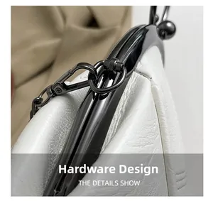 Detailed macro of white leather texture and gunmetal hardware buckle on shell bag