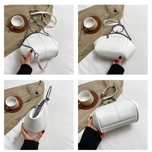 Close-up of white PU leather shell bag with vintage metal clasp and chain strap