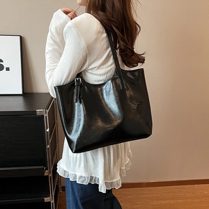 Elegant black glossy faux leather tote bag with large capacity for stylish modern women.