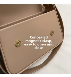 Gros plan des boucles magnétiques dorées invisibles sur le sac à main en cuir beige