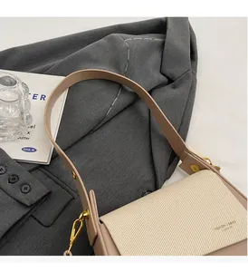 Détail du tissu sergé beige et cuir kaki avec boucle dorée sur le sac à main