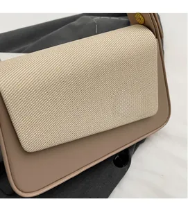 Gros plan détaillé d'un sac à bandoulière en tissu tissé beige et similicuir marron clair