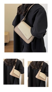 Détail de la texture tissée et de la finition en cuir lisse du sac à bandoulière beige