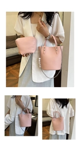 Pink lychee grain bucket bag detail showing silver chain strap and large pearl decorations