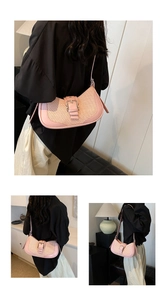 Detailed view of pink shoulder bag featuring woven texture and silver metal buckle