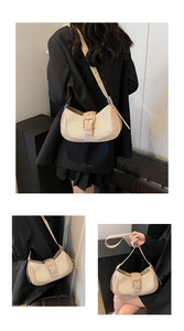 Detail of adjustable leather strap and silver buckle on the beige woven hobo bag