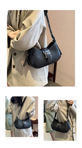 Detail of black baguette bag with silver buckle and adjustable shoulder strap texture