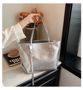 Dettaglio della borsa tote intrecciata argento con manici lunghi e trama metallica