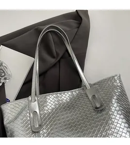 Close-up of silver woven tote bag with metallic texture and minimalist shoulder strap