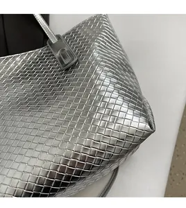 Detailed close-up of the silver woven faux leather texture on the large tote bag