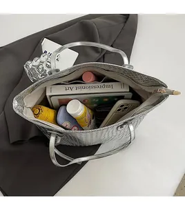 Top view of silver woven tote bag interior showing spacious storage for tablet and books