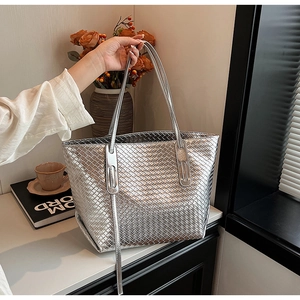 Dettaglio macro della borsa tote intrecciata argento con finitura metallica di lusso
