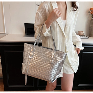 Close-up of metallic silver woven tote bag showing detailed cross-weave texture
