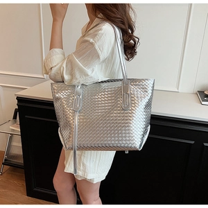 Dettaglio della borsa tote intrecciata argento con nappe a frange sulla spalla