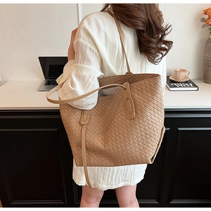 Lifestyle shot of khaki woven tote bag showing spacious interior and fine leather texture