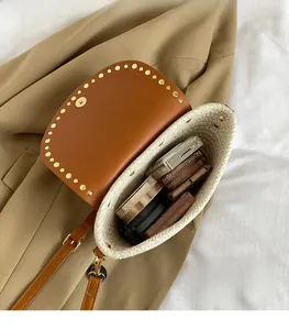 Detail view of woven straw bag with leather flap showing large interior storage space