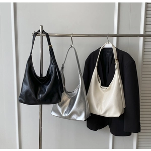 Vue détaillée de grands sacs cabas en noir, argent et beige avec texture cuir plissée