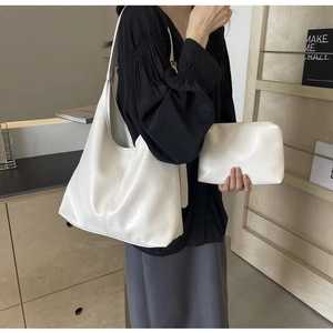 Vue détaillée du grand sac cabas blanc et sa pochette avec texture froissée