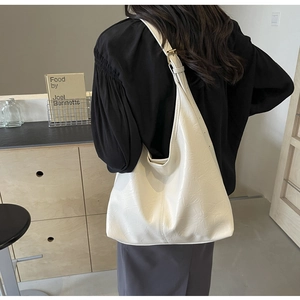 Détail du sac hobo beige minimaliste montrant le cuir PU plissé et la large bandoulière